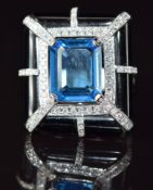 An 18ct white gold ring set with an emerald cut blue topaz, diamonds and black onyx, 13.9g, size N