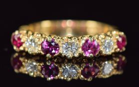 An 18ct gold ring set with alternating rubies and diamonds of approximately 0.13ct each, 3.9g,