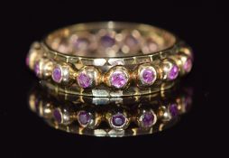 A 9ct gold eternity ring set with pink sapphires, 3.7g, size O/P
