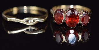 A 9ct gold ring set with three garnets (3.3g, size K/L) and a 14k gold ring set with a diamond, 1.