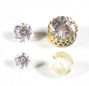A loose yellow sapphire (0.37g), a round cut YAG, and a moissanite