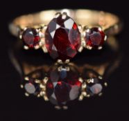 A 9ct gold ring set with three garnets, 2.4g, size P