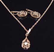 A 14ct rose gold necklace (52cm), pendant (2.5cm) and earrings (1.4cm) with pierced detail, 10.9g