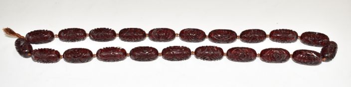 A carved cherry amber necklace, 97g, each bead approximately 2.8cm