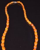 A beaded amber necklace with 9ct gold barrel clasp