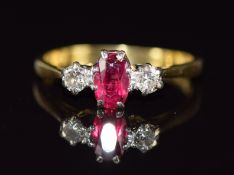 An 18ct gold ring set with an oval cut ruby and diamonds, 2.3g, size L