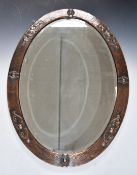 Arts and Crafts / Liberty style copper oval bevelled glass mirror, 62 x 86cm