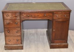 Oak kneehole twin pedestal desk fitted six drawers, writing slide and single cupboard, W 122 x D