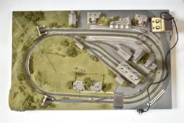 Scratch built N gauge model railway layout with two oval loops of track, sidings, buildings and