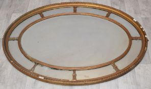 19thC gilt framed mirror with central bevelled oval plate, 111 x 81cm overall