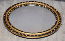 Irish oval mirror, the embossed and gilt frame with applied cabochon and incised cross decoration,