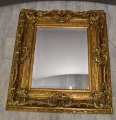 Bevelled mirror in ornate gilt frame, overall size 89 x 100cm