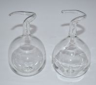 Two blown glass steam engines in the style of Hero