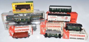 Sixteen Fleischmann 00 gauge model railway coaches, wagons and vans, all in original boxes.