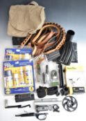 A collection of gun and shooting related items including magazines, cleaning kits, shotgun cartridge