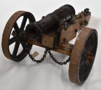 19thC iron barrelled cannon, on wooden carriage with cast iron wheels, overall length 99cm