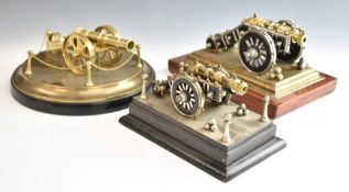 Three model cannon comprising two with studded decoration and wheels and one with circular brass