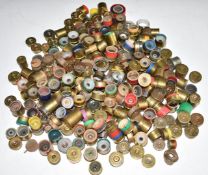 A large collection of brass shotgun cartridge ends, caps or bases. From the collection of Ken