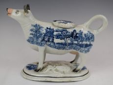 A 19thC cow creamer with relief moulded leaf base and willow pattern decoration, H13cm