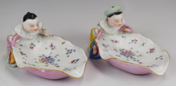 A pair of 19thC porcelain figural Chinese sweetmeat dishes in the style of Meissen, H8cm