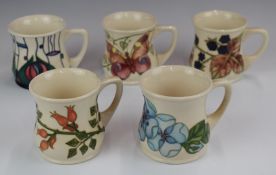 Five Moorcroft mugs decorated in various patterns including Mackintosh, butterflies, flowers etc,