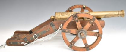 Model cannon with brass or similar barrel and wooden carriage, with plaque to rear suggesting it