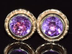 A pair of 9ct gold earrings set with round cut amethysts, 1.6g