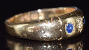 An 18ct gold ring set with a diamond and two sapphires in star settings, Chester 1911, 3.2g, size P