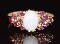 A 9ct gold ring set with an opal cabochon and rubies, 2.7g, size P