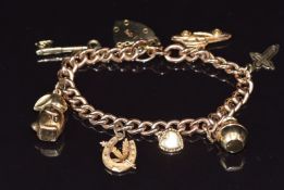 A 9ct gold charm bracelet with seven 9ct gold charms including car, cross, rabbit, etc, 13.1g, 18 cm