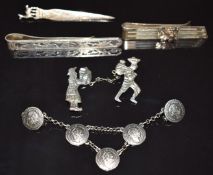 Three Peruvian silver money clips, silver Peruvian cloak brooch, and another brooch