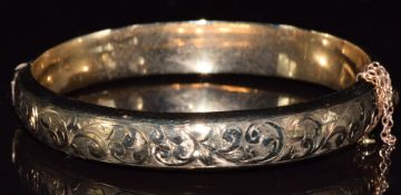 A 9ct gold bangle with scrolling foliate decoration,13.6g