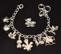 A silver charm bracelet with 11 silver charms including thistle, cat, dragon, etc