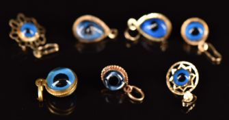 Seven 14k gold eye pendants