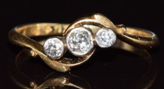 An 18ct gold ring set with three diamonds in a twist setting, 2g, size N