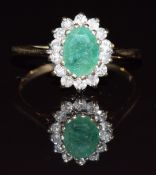 A 9ct gold ring set with an oval cut emerald surrounded by diamonds, 1.8g, size K/L