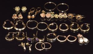 Eighteen pairs of 9ct gold earrings including amethyst, hoops, knots, etc, 15.9g