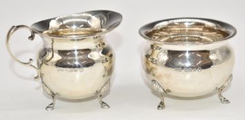 George V hallmarked silver sugar bowl and milk jug, each raised on three feet, Birmingham 1934,