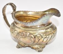 Georgian hallmarked silver milk jug with gilt interior, raised on four feet, marks rubbed but likely