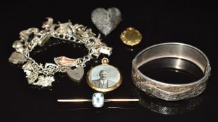 A 9ct gold locket pendant (Birmingham 1912), silver bangle with engraved foliate decoration,