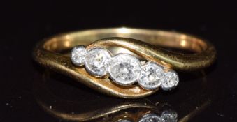 An 18ct gold ring set with five diamonds in a twist setting, 2.6g, size N