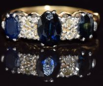 An 18ct gold ring set with three oval sapphires and diamonds, 4.4g, size L