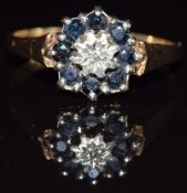 A 9ct gold ring set with a diamond surrounded by sapphires, 1.9g, size N