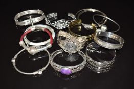 Twelve silver bangles including 'nymph', Siam, mother of pearl, etc
