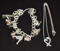 A silver charm bracelet with 9 silver charms including a surfer, rhino, train, dog, bird, etc and