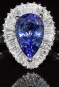 A platinum ring set with a pear cut tanzanite of approximately 2.1ct surrounded by baguette cut