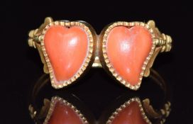 A 19thC gold ring set with two heart cut coral cabochons, 5g, size T