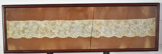 18thC lace sample mounted on cloth in glazed frame, 7 x 58cm