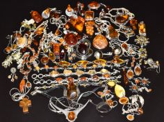 A collection of silver pendants, earrings, bracelets set with amber
