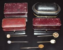 A gold $1 coin stick pin (2.5g), 9ct gold stick pin set with a diamond, three other stick pins and